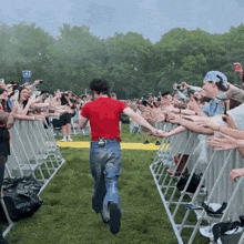 a man in a red shirt is running towards a crowd