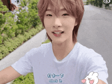 a young man wearing a white t-shirt says clock in in chinese