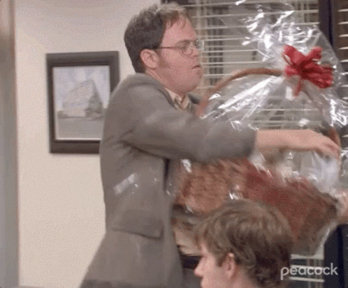 Dwight from The Office with gift basket and Dunder Mifflin hat