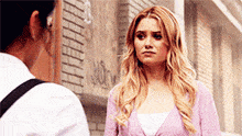 a woman in a purple cardigan is standing next to another woman