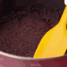 a yellow spatula is being used to spread oreo crumbs