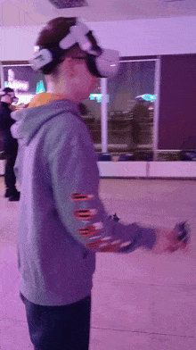 a person wearing a virtual reality headset holds a remote control