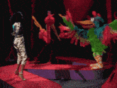a woman in a gold outfit is dancing with a colorful costume