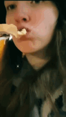 a close up of a woman eating a piece of bread
