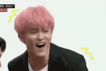 a man with pink hair is making a funny face while wearing a suit and tie .