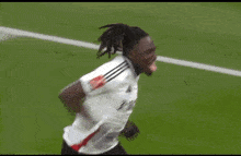 a soccer player wearing a white jersey with the word adidas on it