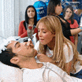 a woman talks to a man in a hospital bed with a balloon in the background that says " fuel "
