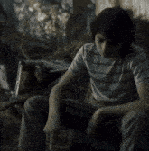 a man in a black shirt stands in the woods