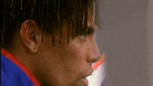 a close up of a man 's face with dreadlocks on it