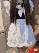 a girl in a maid costume stands in front of a teddy bear