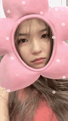 a girl wearing a pink flower shaped hat with stars on it