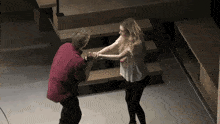 a man in a red shirt is holding the hand of a woman