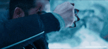 a close up of a man holding a sword with nandamurifans.com written on the bottom right