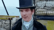 a man wearing a top hat and a suit is looking at the camera