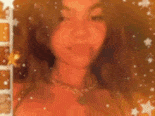 a blurry picture of a woman with long hair wearing a necklace and a necklace .