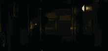 a person standing in a dark hallway with a light on the wall