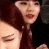 a close up of two women 's faces with their eyes closed and their mouths open .