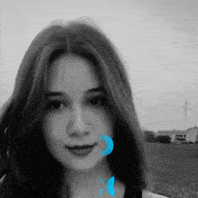 a black and white photo of a woman 's face with a blue circle around her mouth