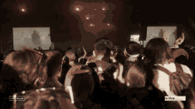 a crowd of people at a concert with a screen that says fire on it