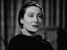 a black and white photo of a woman 's face and neck