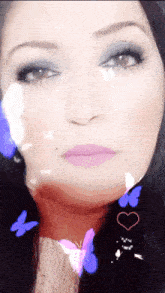 a close up of a woman 's face with butterflies flying around her
