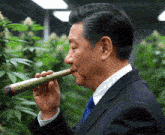 a man in a suit and tie smoking a cigar