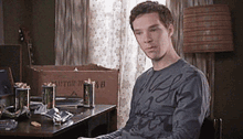 a man is sitting at a desk with a box that says meter on it in the background