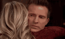 a man and a woman are hugging each other .