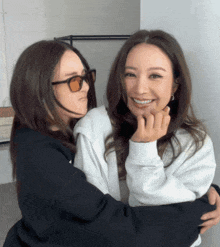 two women are hugging each other and one has sunglasses on