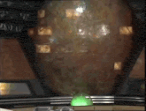a green light is sitting on a table in front of a large object .