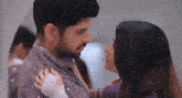 a man and a woman are kissing each other in a room .