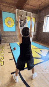 a man is playing basketball in a gym with a sign that says lemonade on the floor