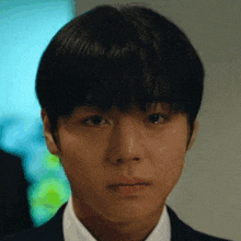 a close up of a young man 's face in a suit