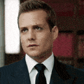 a man in a suit and tie looks to the side