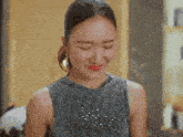 a woman in a sequined top is smiling with a tumblr logo in the background