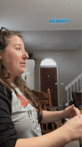 a woman wearing a shirt with the number 19 on it is sitting in a living room