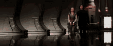 a man and a woman are standing next to each other in a room .