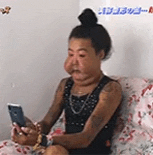 a woman with a huge nose is sitting on a couch looking at her phone .