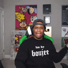 a man wearing a black shirt that says low key boujee on it