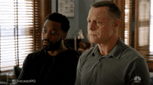 two men sitting in front of a window with the hashtag #chicagopd on their shirts