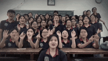 a group of students are posing for a picture in front of a chalkboard that says ' a ' on it