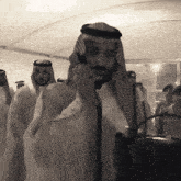 a man talking on a cell phone in front of a crowd