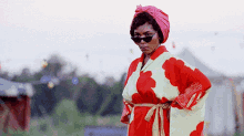 a woman wearing a red and white kimono and a pink turban