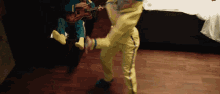 a man in a yellow suit is kicking another man in a green suit