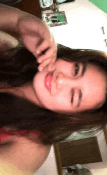 a woman is taking a selfie with her hand on her face