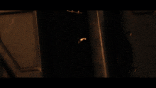 a close up of a person 's face in a dark room with fire in the background