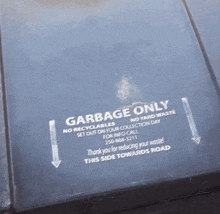 a garbage only sign on the side of a trash can