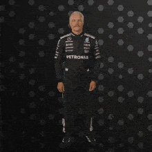 a man in a petronas outfit is clapping