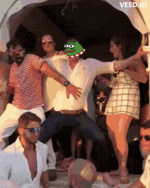 a group of people are dancing with a man wearing a pepe head