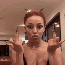 a woman with red hair is giving the middle finger .
